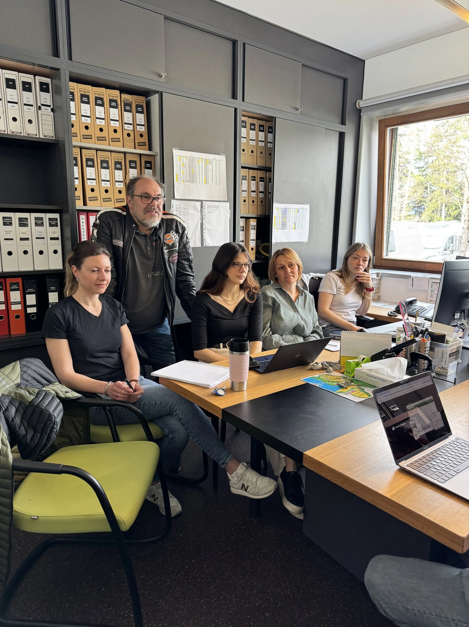 Das Team vom Natterer See rundum Georg Giner sitzt am Schreibtisch und hört aufmerksam einer Schulung zu
